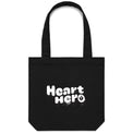 Heart Foundation black canvas tote bag shown with vintage look Heart hero text in white print on the front